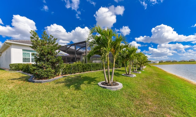 view of green lawn with a water view and glass enclosure