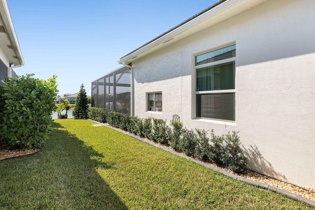 view of grassy yard with a lanai