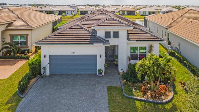 view of front of home featuring a residential view, a tile roof, a garage, and driveway