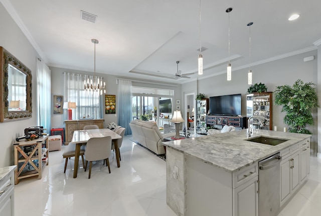 kitchen with a sink, ceiling fan, a raised ceiling, dishwasher, and open floor plan