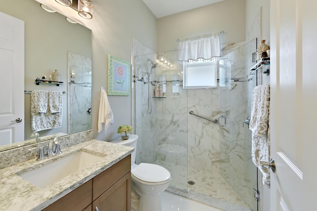full bath with a marble finish shower, toilet, and vanity