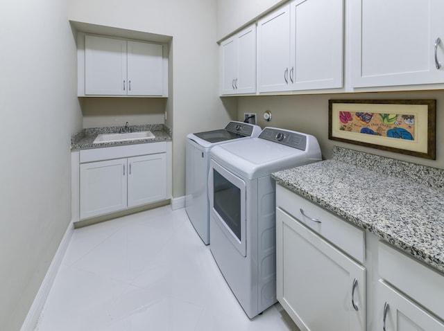 clothes washing area with cabinet space, washer and dryer, baseboards, and light tile patterned flooring
