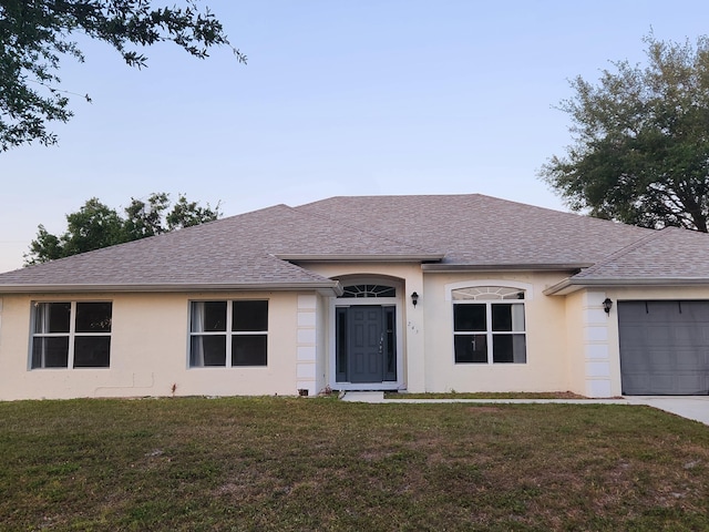 ranch-style home with stucco siding, an attached garage, a shingled roof, and a front yard