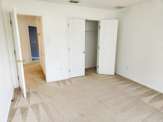 unfurnished bedroom featuring baseboards, visible vents, carpet, and a closet