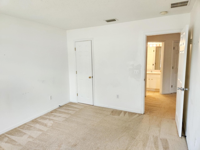 unfurnished room featuring light carpet, visible vents, and baseboards