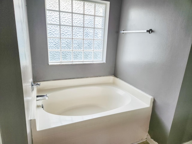 bathroom featuring plenty of natural light and a garden tub