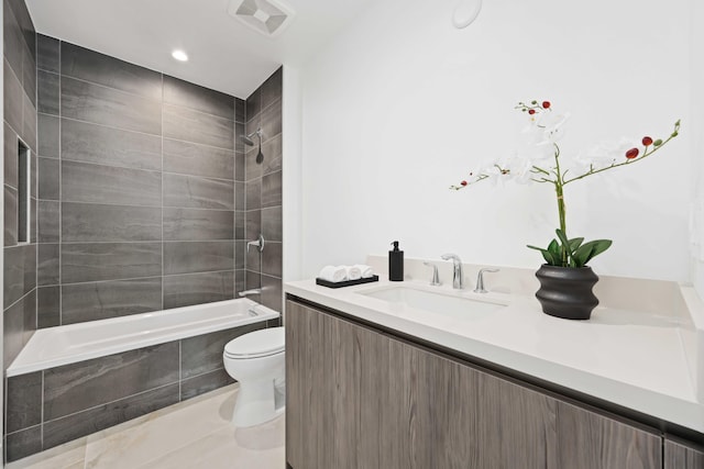 full bathroom featuring tiled shower / bath combo, vanity, and toilet