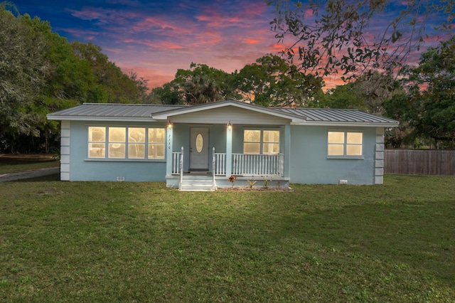 single story home with a porch and a lawn