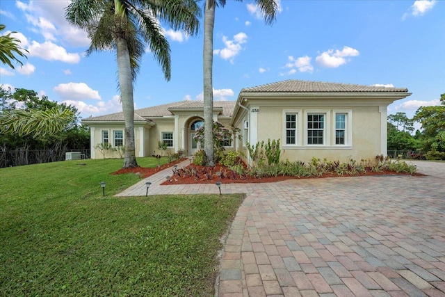 mediterranean / spanish house featuring a front lawn