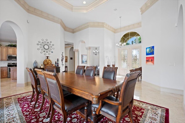 dining area with crown molding, a towering ceiling, a tray ceiling, and a notable chandelier