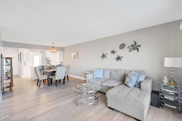 living room with an inviting chandelier and light hardwood / wood-style flooring