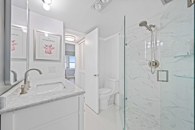 bathroom with a shower with door, vanity, and toilet