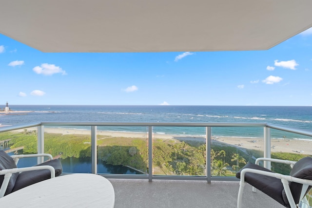 balcony featuring a view of the beach and a water view