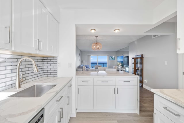 kitchen featuring white cabinetry, sink, light stone counters, and light hardwood / wood-style floors