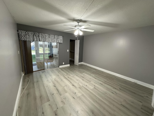 2201 Lucaya Bnd Unit M1, Coconut Creek, FL 33066 - unfurnished bedroom with baseboards, a ceiling fan, a textured ceiling, and wood finished floors