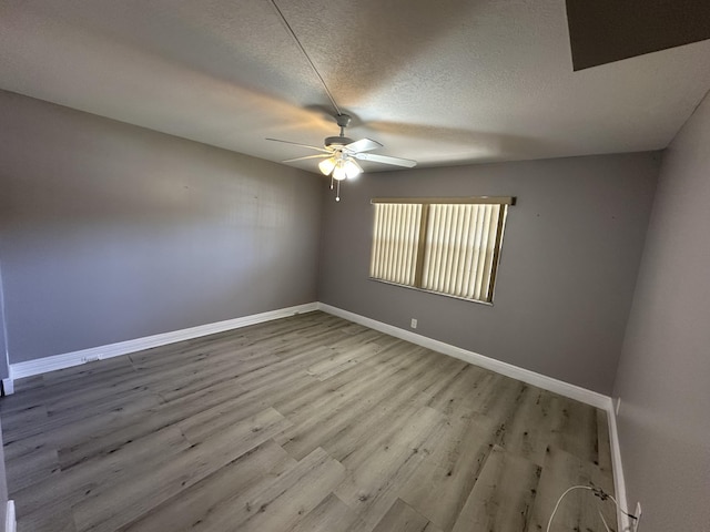 2201 Lucaya Bnd Unit M1, Coconut Creek, FL 33066 - empty room with baseboards, ceiling fan, light wood-type flooring, and a textured ceiling