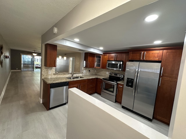 2201 Lucaya Bnd Unit M1, Coconut Creek, FL 33066 - kitchen with appliances with stainless steel finishes, tasteful backsplash, light wood-type flooring, a sink, and glass insert cabinets