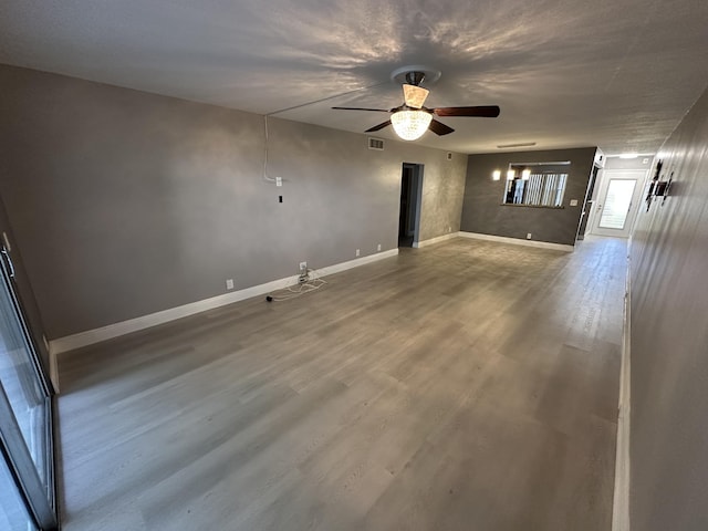 2201 Lucaya Bnd Unit M1, Coconut Creek, FL 33066 - unfurnished living room featuring visible vents, baseboards, ceiling fan, and wood finished floors