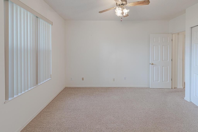 spare room featuring light carpet and ceiling fan