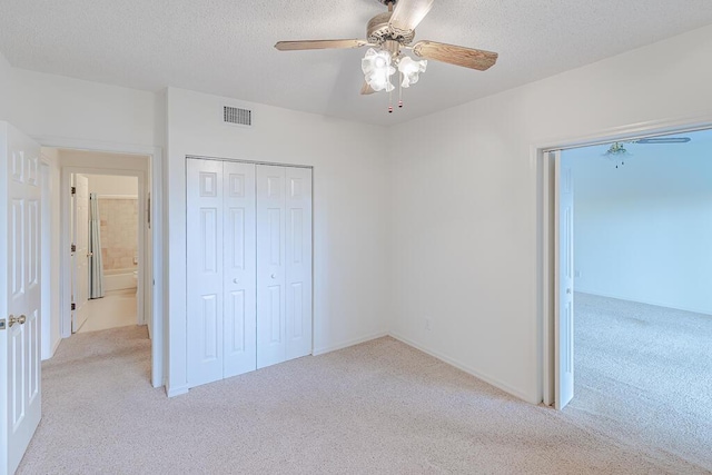 unfurnished bedroom featuring light carpet, ceiling fan, and a textured ceiling