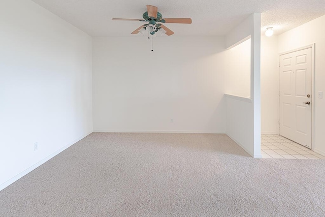 carpeted empty room with ceiling fan and a textured ceiling