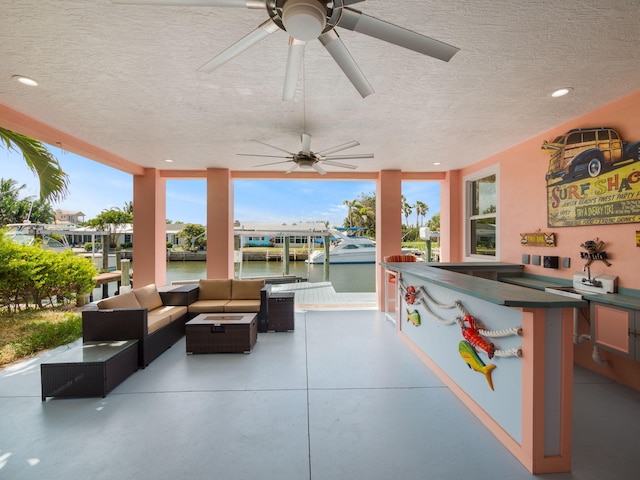 view of patio with an outdoor hangout area, an outdoor bar, and a water view