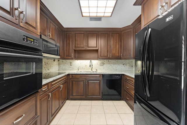 kitchen featuring visible vents, tasteful backsplash, a sink, black appliances, and light tile patterned floors
