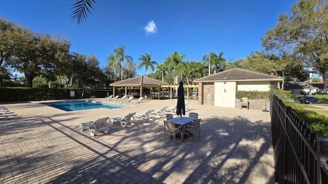 community pool featuring fence, a gazebo, and a patio area
