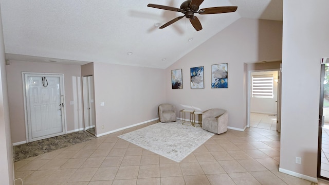 sitting room with light tile patterned flooring, baseboards, vaulted ceiling, and a ceiling fan