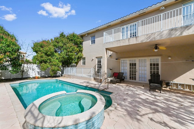 view of pool featuring a patio, a fenced backyard, a pool with connected hot tub, a ceiling fan, and french doors