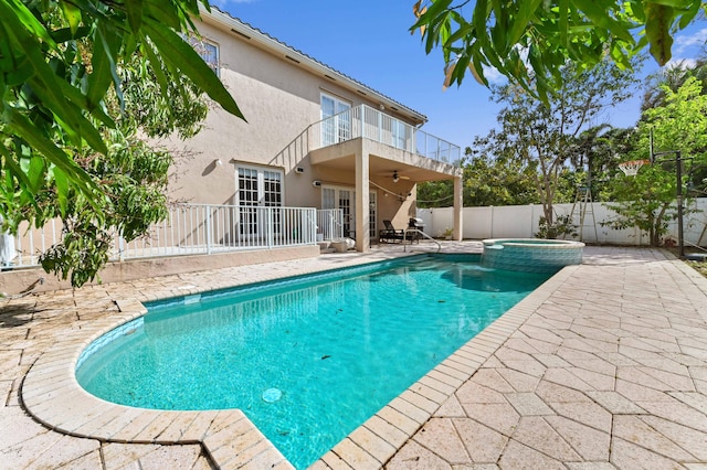 view of swimming pool featuring a pool with connected hot tub, a patio, ceiling fan, and a fenced backyard