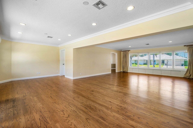 unfurnished living room with crown molding, wood finished floors, visible vents, and a textured ceiling