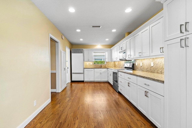 kitchen with white appliances, baseboards, dark wood-style flooring, white cabinetry, and tasteful backsplash