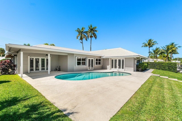 exterior space featuring stucco siding, a patio, french doors, a yard, and a fenced in pool