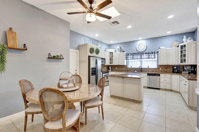 kitchen with a kitchen island, tasteful backsplash, sink, ceiling fan, and stainless steel appliances