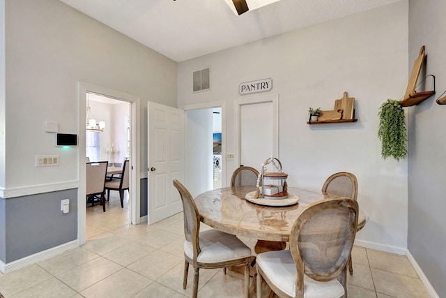 dining space featuring light tile patterned floors and a chandelier