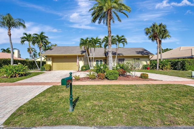 ranch-style home featuring a garage and a front yard