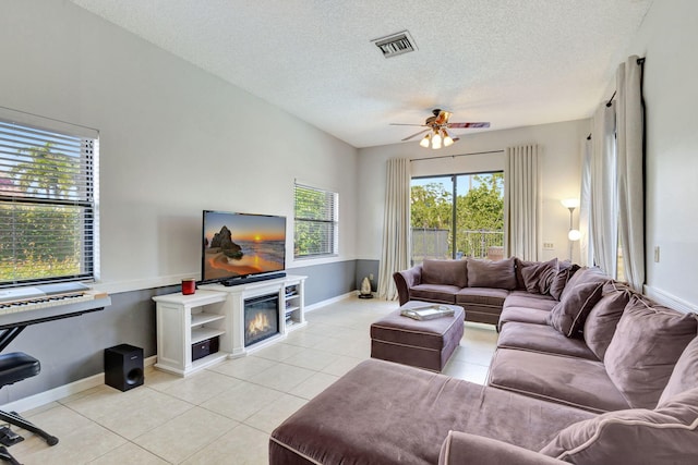 tiled living room with ceiling fan and a textured ceiling