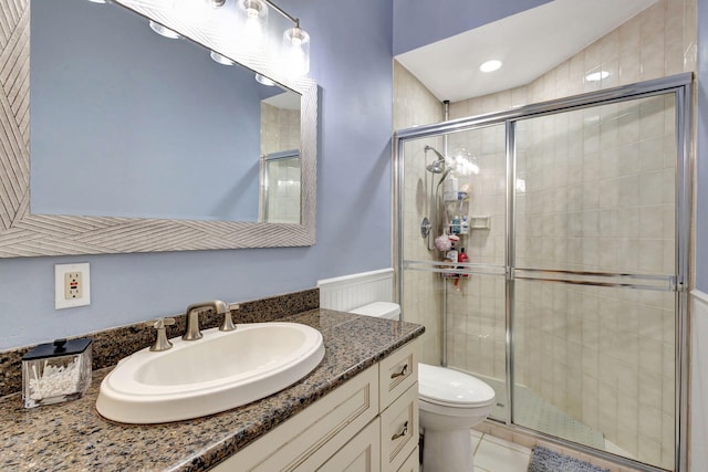 bathroom with tile patterned flooring, vanity, walk in shower, and toilet