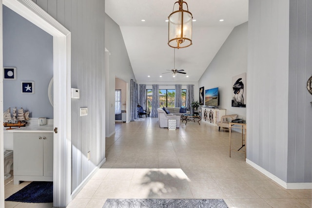 foyer with light tile patterned floors, high vaulted ceiling, and ceiling fan