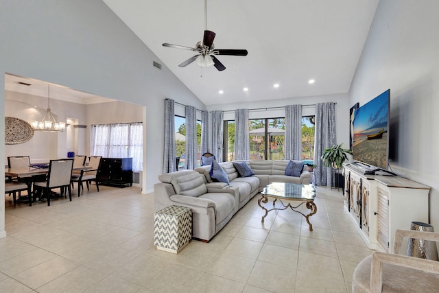 tiled living room featuring plenty of natural light, ceiling fan with notable chandelier, and high vaulted ceiling