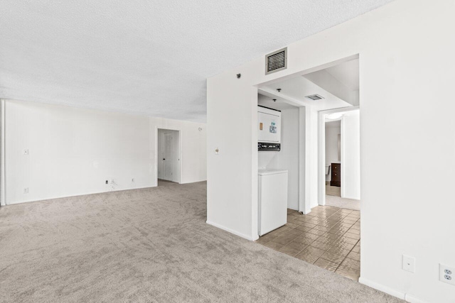 empty room featuring light colored carpet and a textured ceiling