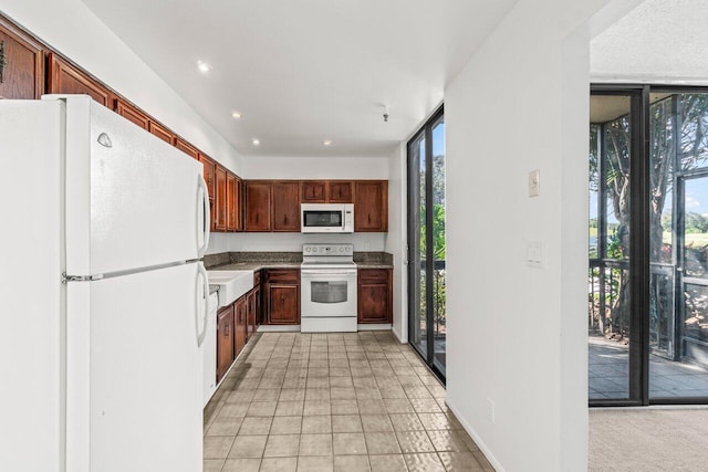 kitchen featuring white appliances, a healthy amount of sunlight, and a wall of windows