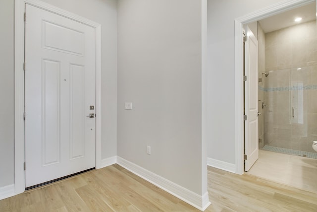 foyer with light wood-type flooring and baseboards