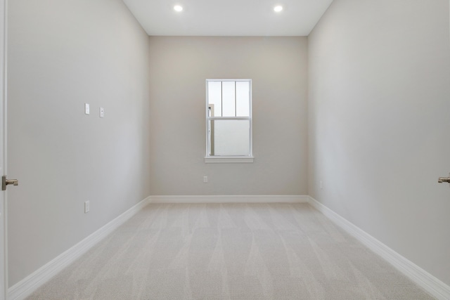 empty room with recessed lighting, light colored carpet, and baseboards