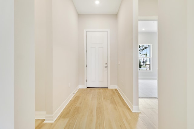 hallway with light wood-type flooring and baseboards