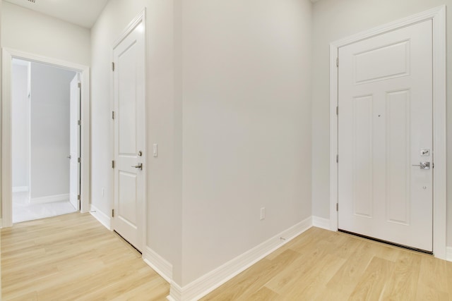 foyer entrance with light wood-style flooring and baseboards