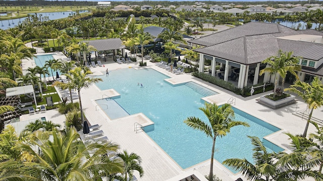 pool with a patio, a water view, fence, and a pergola