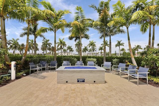 view of community featuring a fire pit and a patio