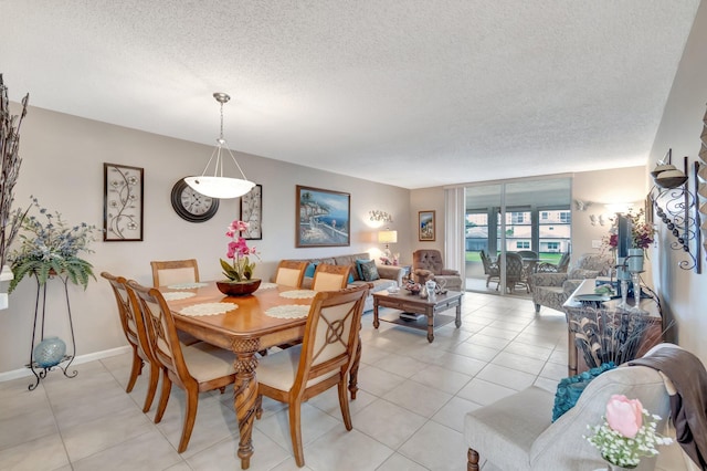 dining room featuring light tile patterned floors, baseboards, and a textured ceiling